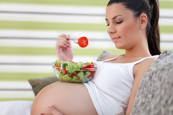 Une femme enceinte mange de la salade