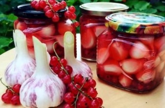 กระเทียมดองกับลูกเกดแดงในขวดบนโต๊ะ