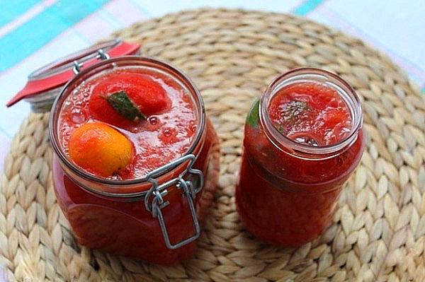 มะเขือเทศเชอร์รี่ในน้ำของตัวเองในขวดบนโต๊ะ