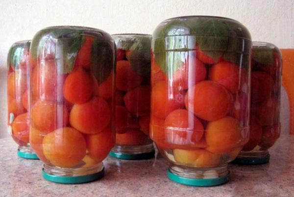 มะเขือเทศกับใบราสเบอร์รี่ในขวดบนโต๊ะ